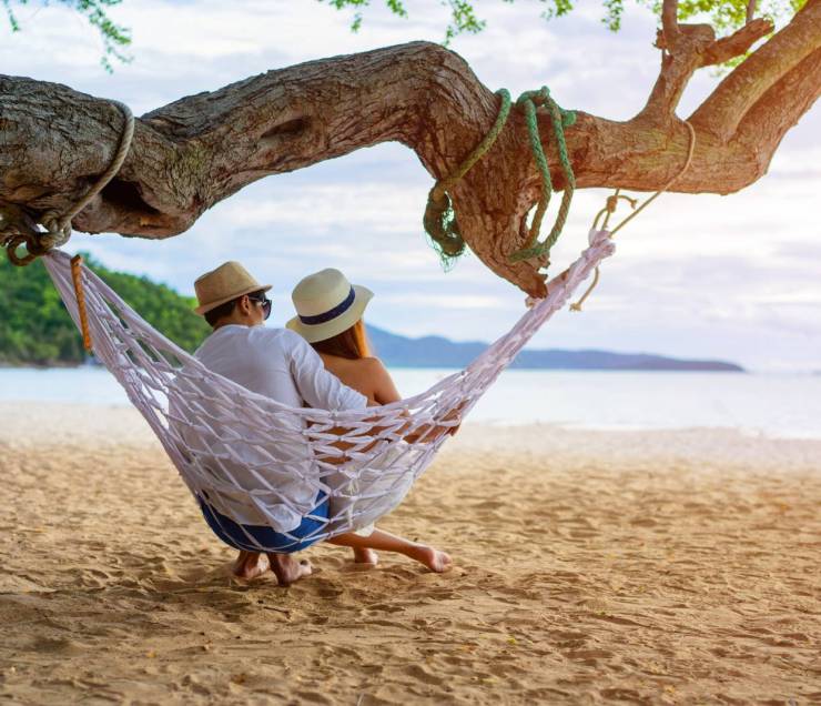 couple lover enjoy honeymoon and long vacation on the sea beach, siiting on the swing together relax and confortable, valentine occasion